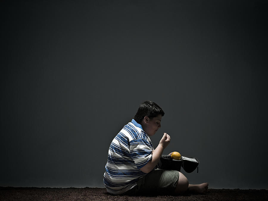 Boy eating packed lunch Photograph by Image Source