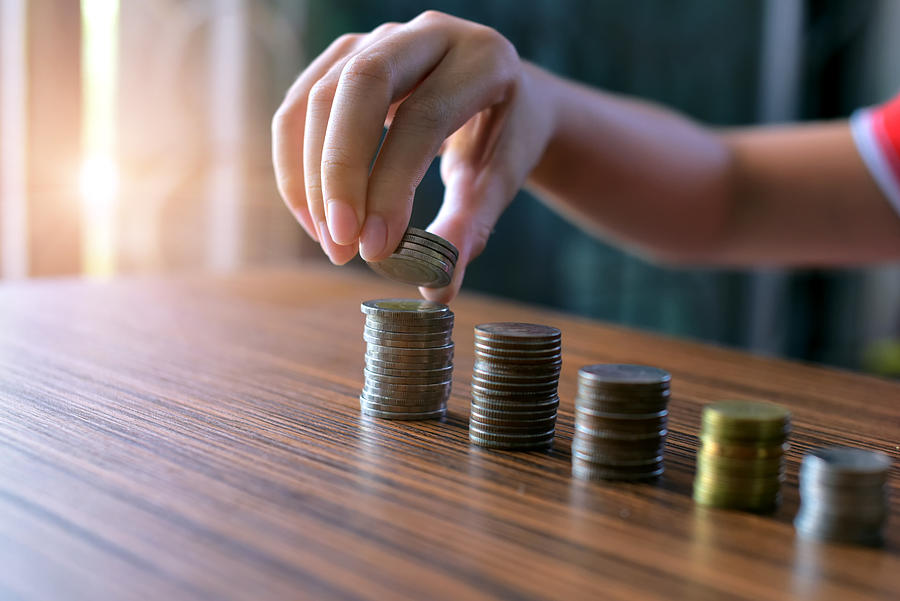 Boy Hand Put Coins To Stack Of Coins .savings, finances, economy and home concept Photograph by Sarote Pruksachat