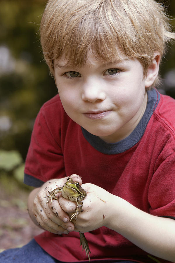 Boy holding a frog Photograph by Comstock