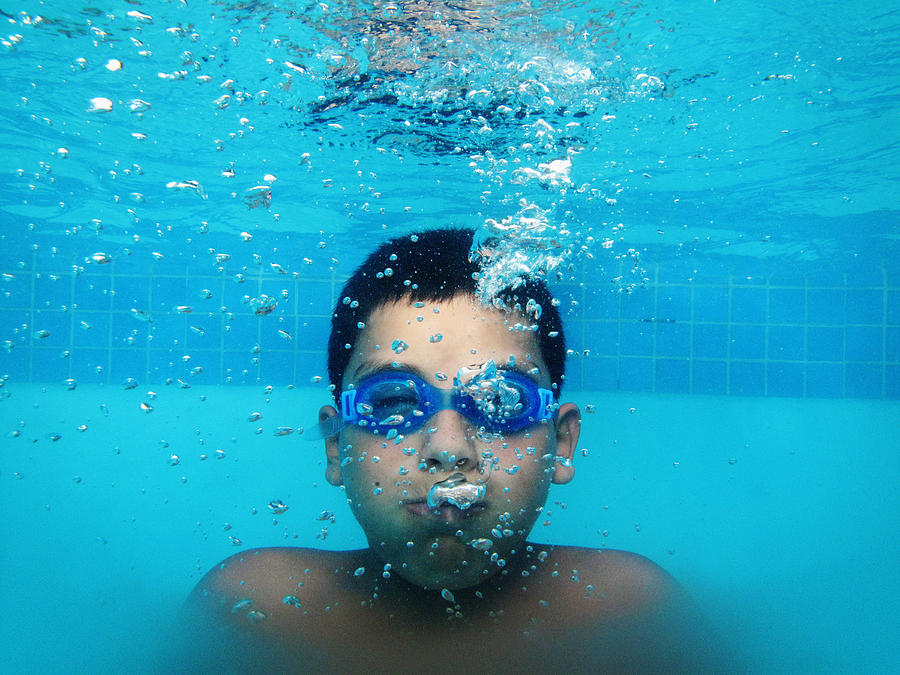 Boy holding his breath underwater in swimming pool Photograph by Holly Wilmeth