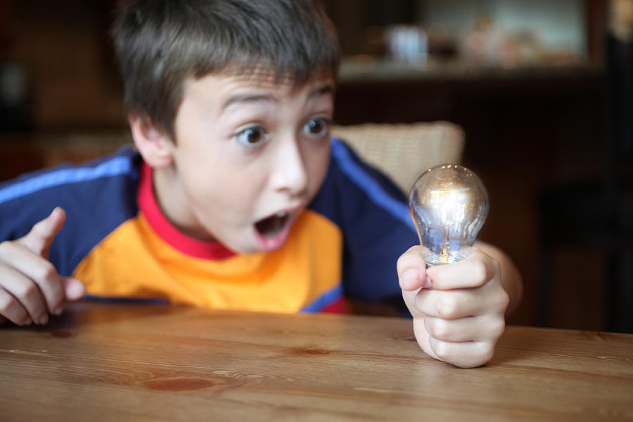 Boy holding light bulb Photograph by RBFried