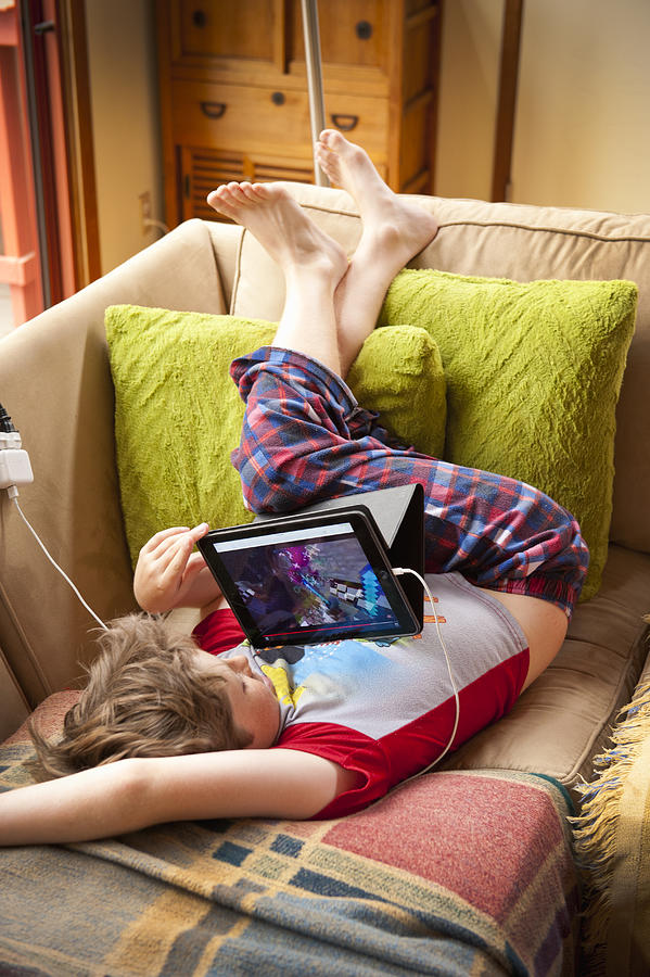 Boy In Pajamas On Couch With Tablet Photograph by Stephen Simpson