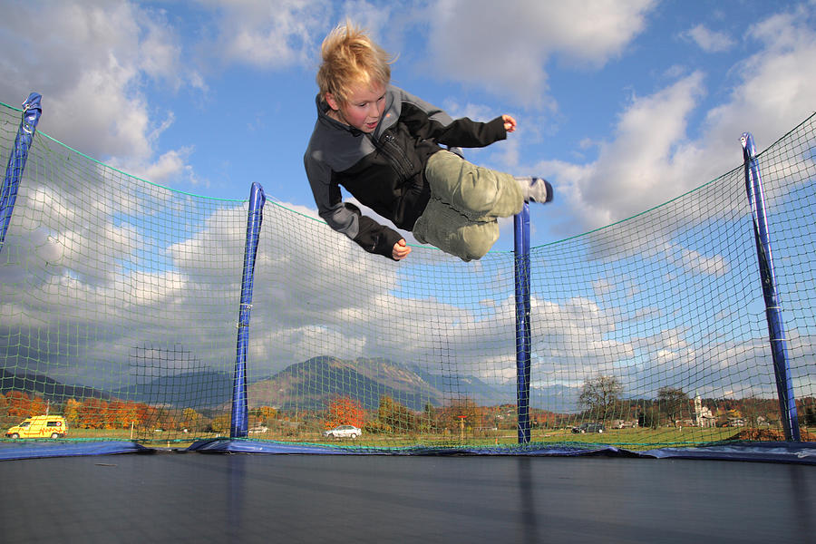 Boy Jumping on Trampoline Photograph by Bikec