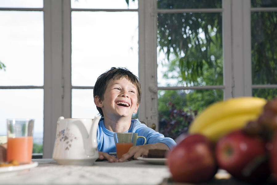 Boy Laughs During Breakfast Photograph by Didier Robcis