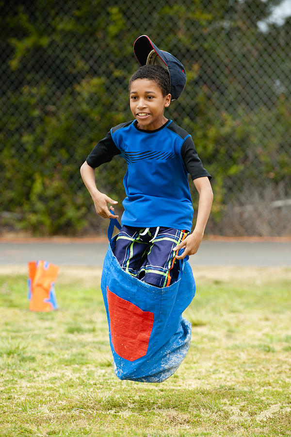 Boy Leaping In School Sack Race Photograph by Stephen Simpson