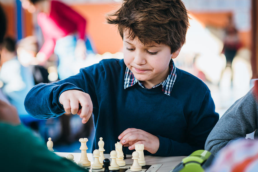 Boy playing in a chess school championship Photograph by Click&Boo