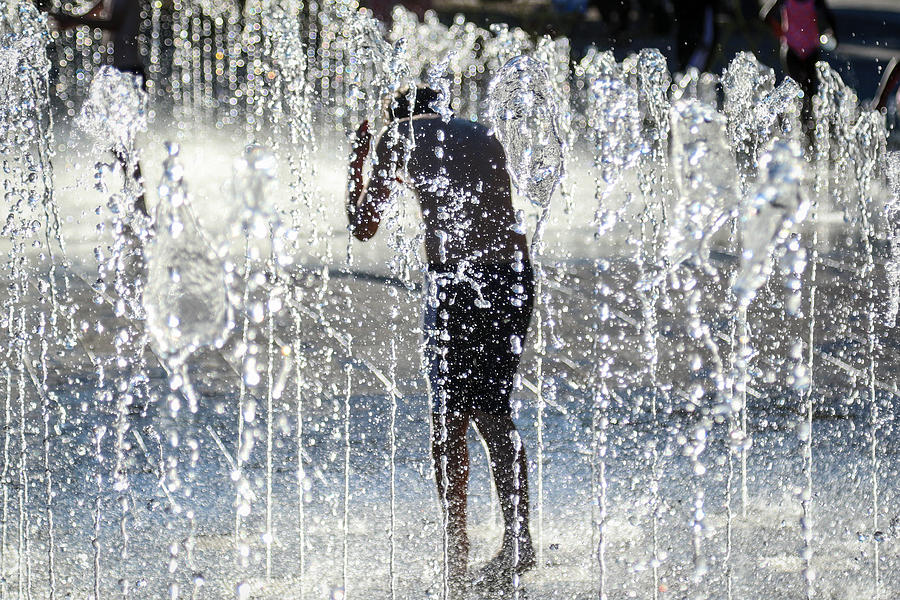 Boy playing in shower fountain Photograph by Paul Mansfield Photography