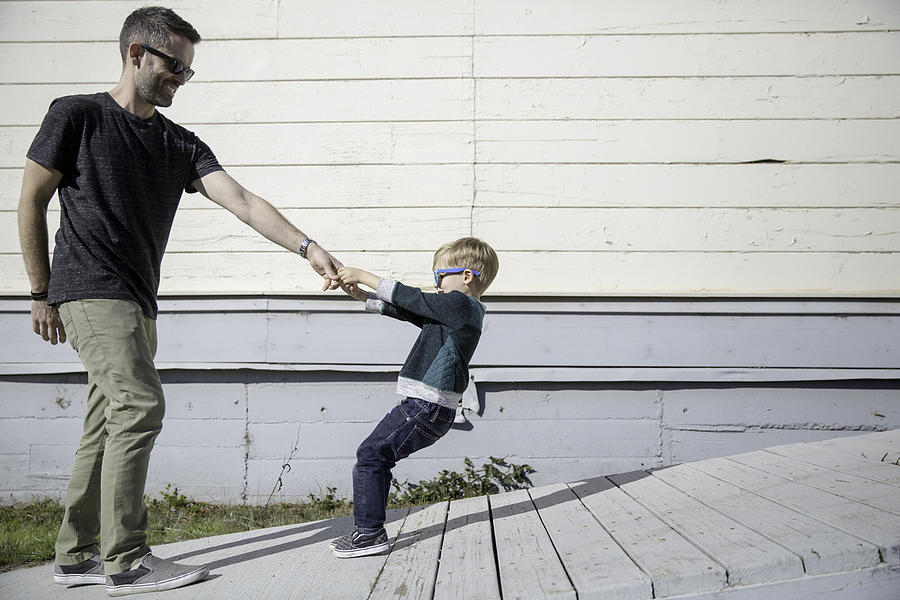 Boy pulling father up wooden ramp Photograph by Sasha Gulish