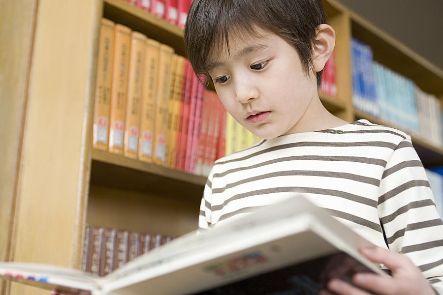 Boy reading a book Photograph by Image Source