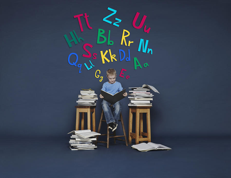 Boy reading books. Cartoon letters Photograph by Flashpop