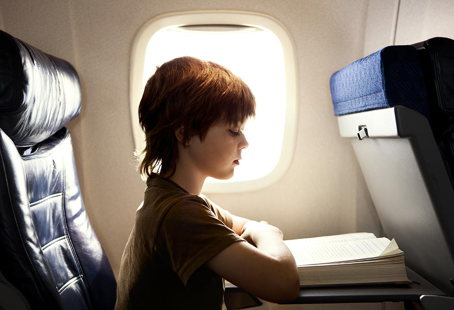 Boy Reading On A Plane Photograph by Blaise Hayward