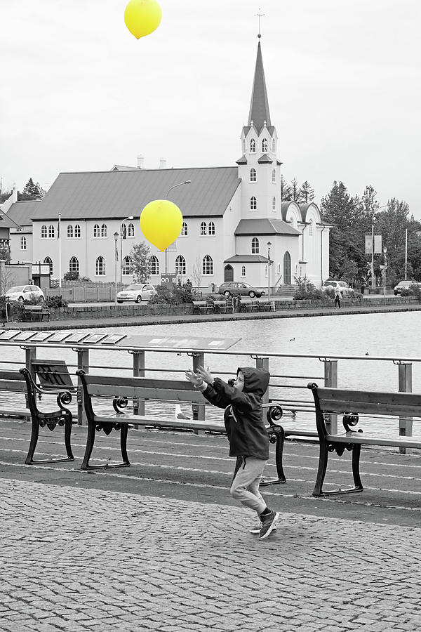 Balloon Photograph - Boy releasing yellow balloons into the air, in Iceland by Carolina Reina