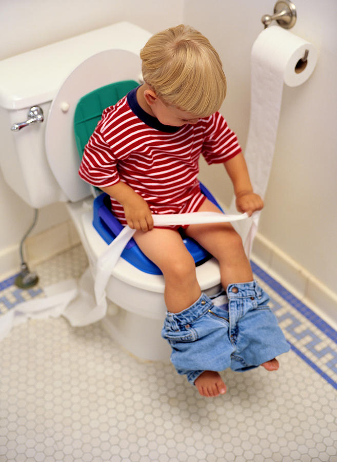 Boy Sitting on a Potty Chair With Toilet Paper Photograph by Ryan McVay