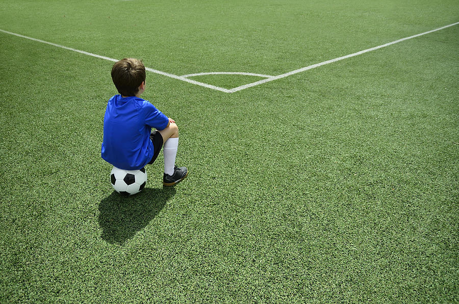 Boy sitting on football Photograph by Paulo Dias Photography
