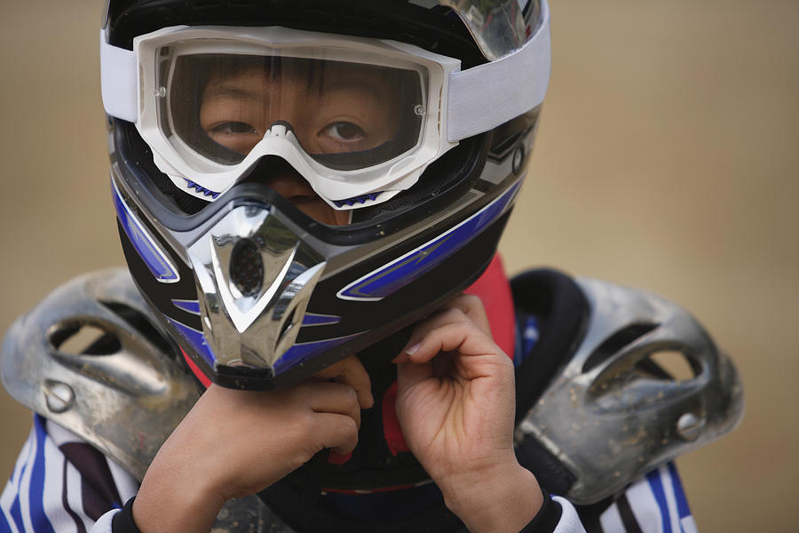 Boy Taking off Helmet Photograph by Nate Jordan/Aflo