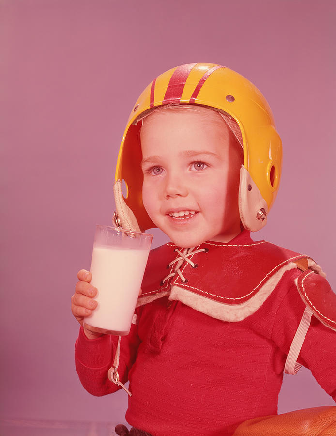 Boy wearing American football kit, holding glass of milk. (Photo by H. Armstrong Roberts/Retrofile/Getty Images) Photograph by H. Armstrong Roberts