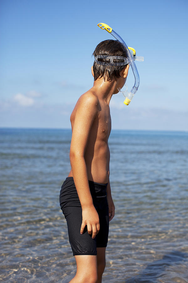 Boy wearing snorkel on beach Photograph by Caia Image