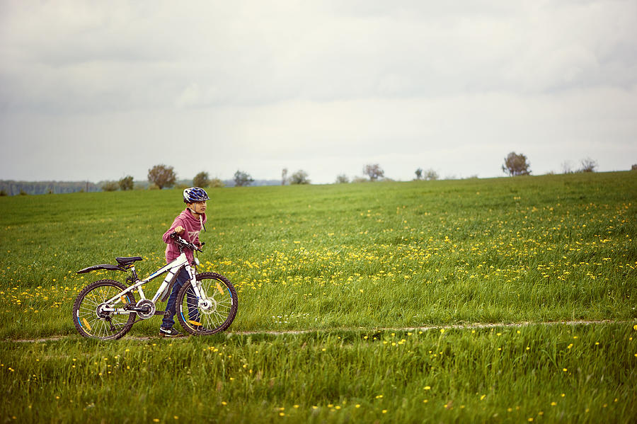 Boy wheeling a bike up a hill Photograph by Elisabeth Schmitt