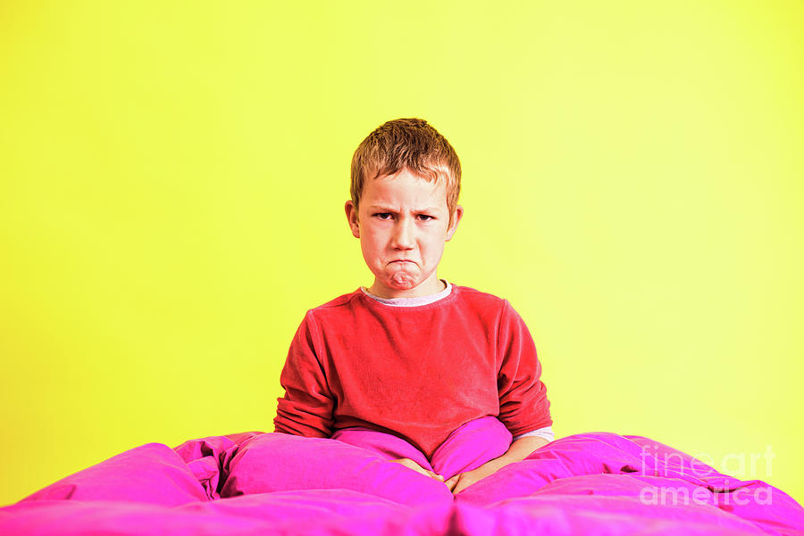 Boy with a gesture of disgust wakes up in the morning in his bed Photograph by Joaquin Corbalan