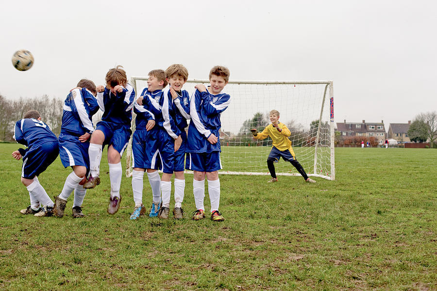 Boys defending free kick during football game Photograph by Jw Ltd