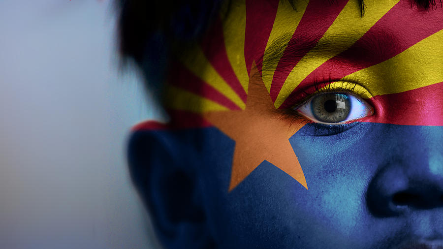 Boys face, looking at camera, cropped view with digitally placed Arizona State flag on his face. Photograph by Mariano Sayno