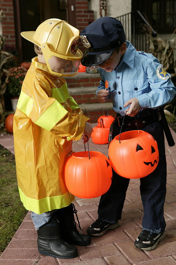 Boys in Halloween costumes looking at candy Photograph by Comstock Images