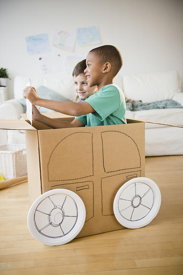 Boys playing in a cardboard car together Photograph by Blend Images - JGI/Jamie Grill