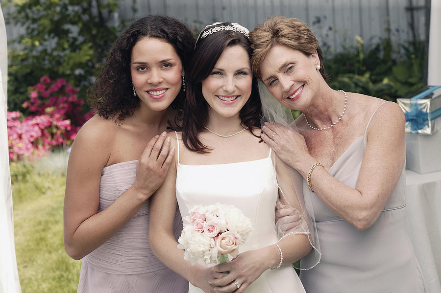 Bride , mother , and bridesmaid Photograph by Comstock Images