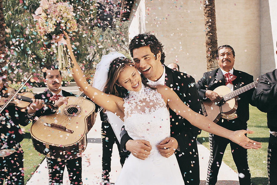 Bride and Groom Celebrating With Confetti and a Mariachi Band Photograph by Digital Vision.