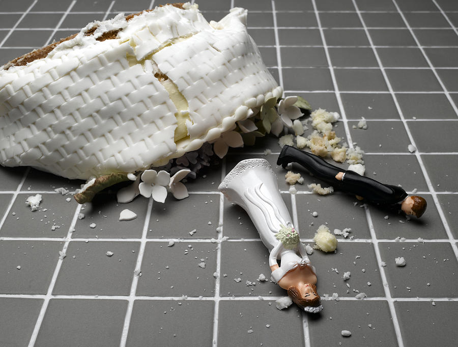 Bride and groom figurines lying at destroyed wedding cake on tiled floor Photograph by Jeffrey Hamilton