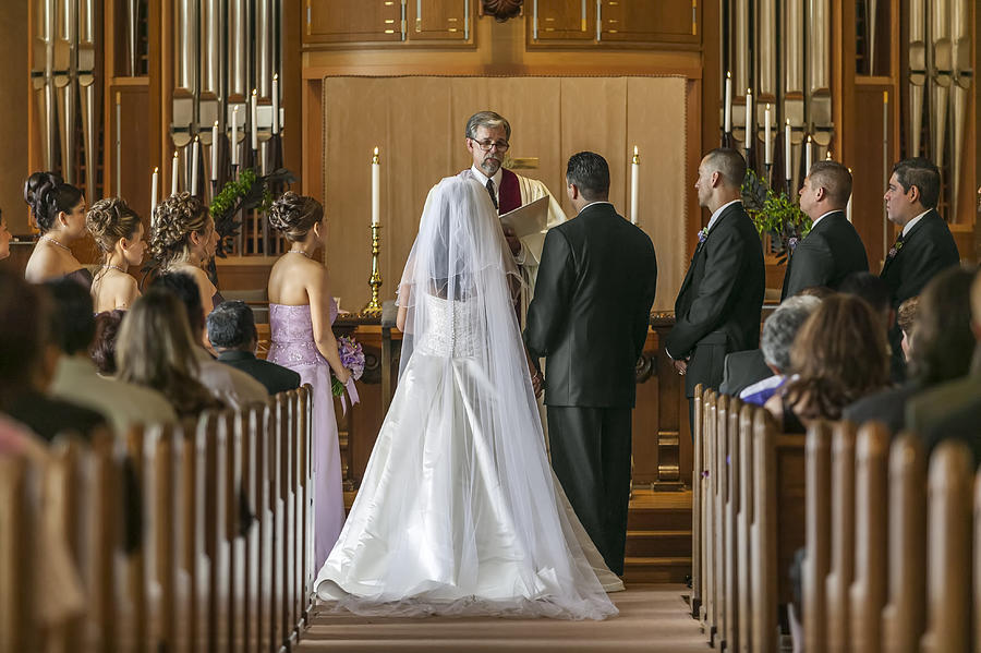Bride and groom standing at altar during wedding ceremony Photograph by Lanny Ziering