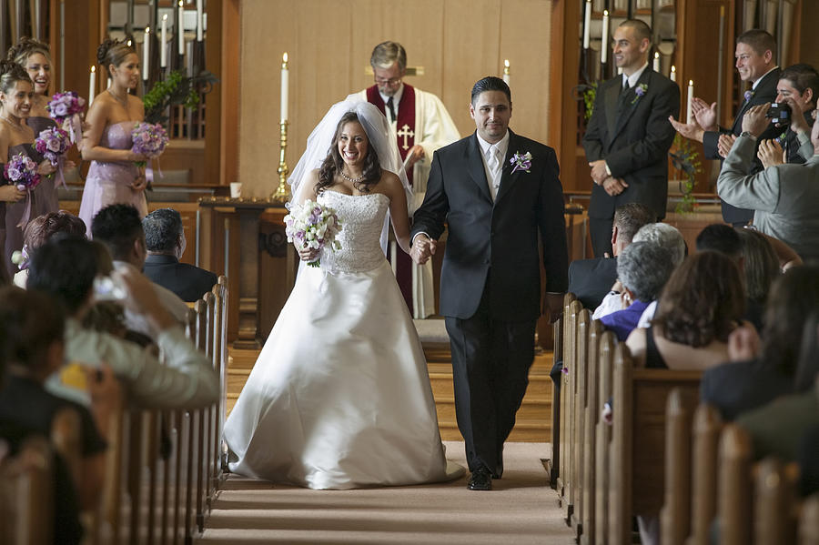 Bride and groom walking down aisle during wedding ceremony Photograph by Lanny Ziering
