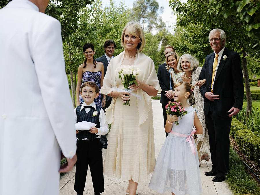 Bride with wedding guests, smiling at groom Photograph by Marc Debnam