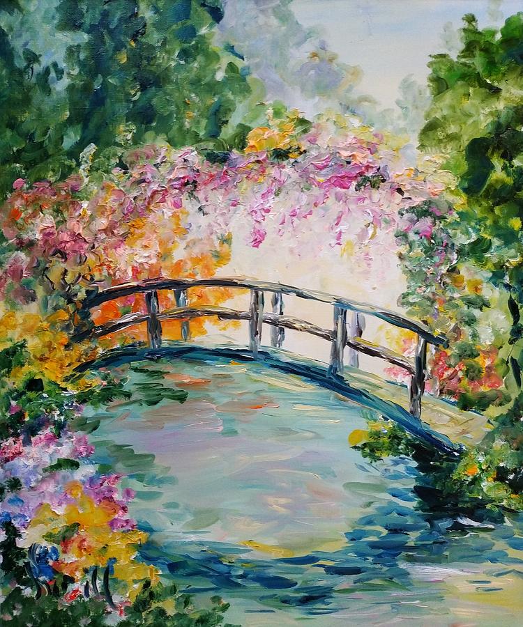 Bridge on aA bridge in a blooming spring garden over a pond surrounded ...