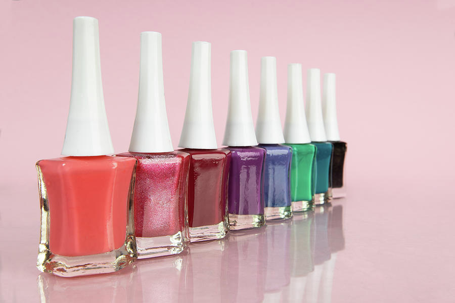 Bright Nail Polishes In Different Colors On Pink Background Photograph
