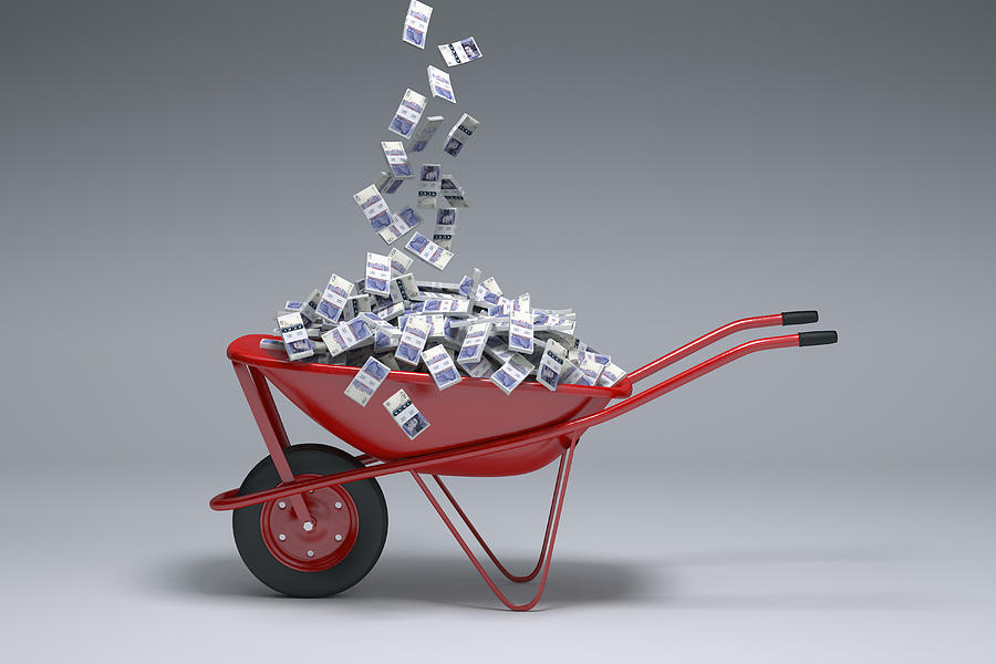 British pounds falling into red wheelbarrow Photograph by Chris Clor