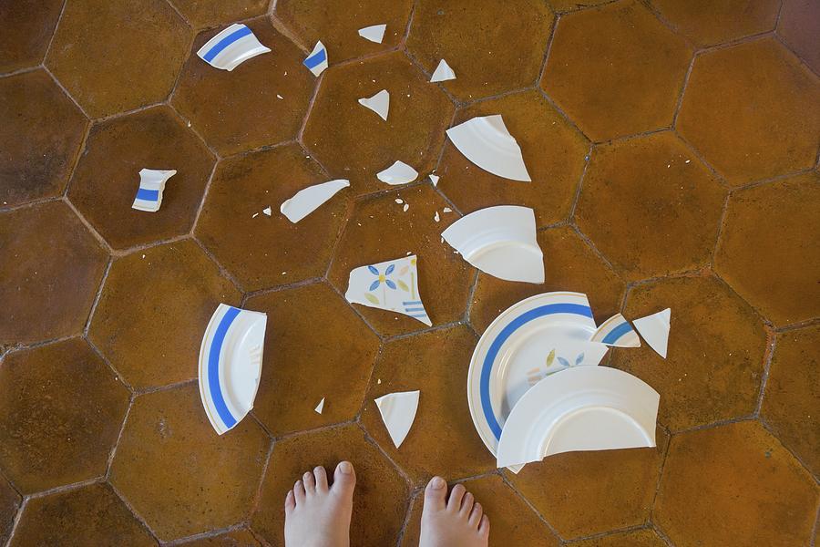 Broken plate next to childs bare feet Photograph by John M Lund Photography Inc
