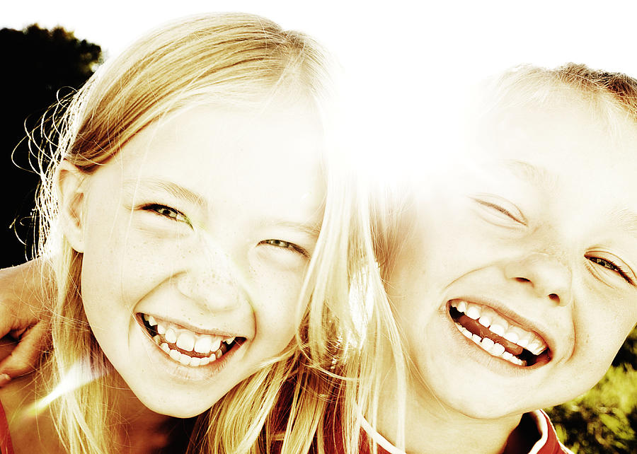 Brother and sister laughing in the sunlight Photograph by David Trood