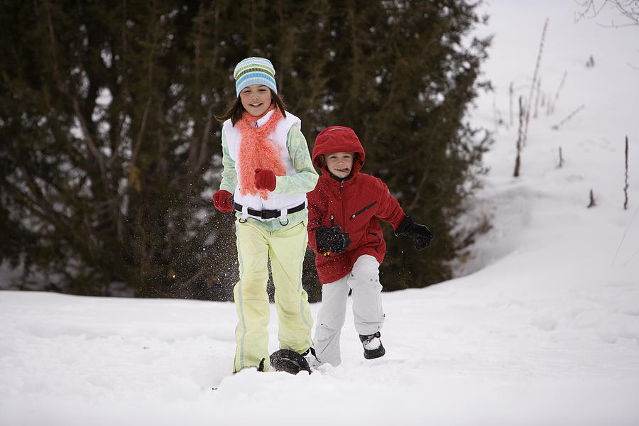 Brother and sister playing in the snow Photograph by Comstock Images