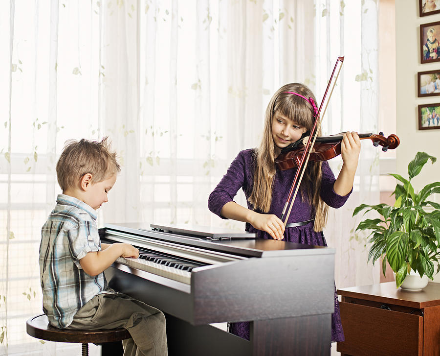 Brother and sister practicing piano, violin Photograph by Imgorthand