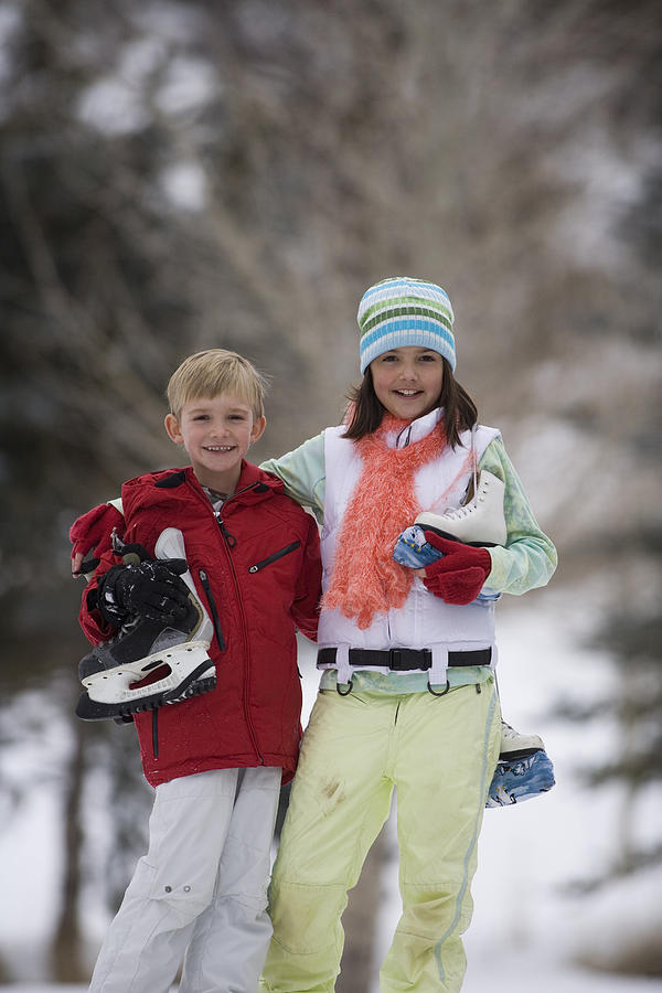Brother and sister with ice skates Photograph by Comstock Images