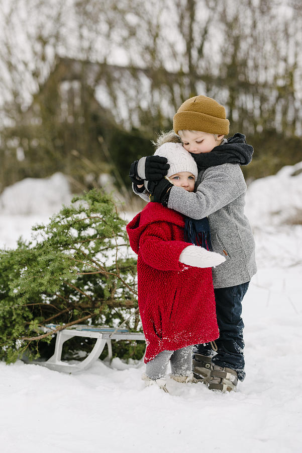 Brother hugs sister during Christmas Photograph by Visualspace