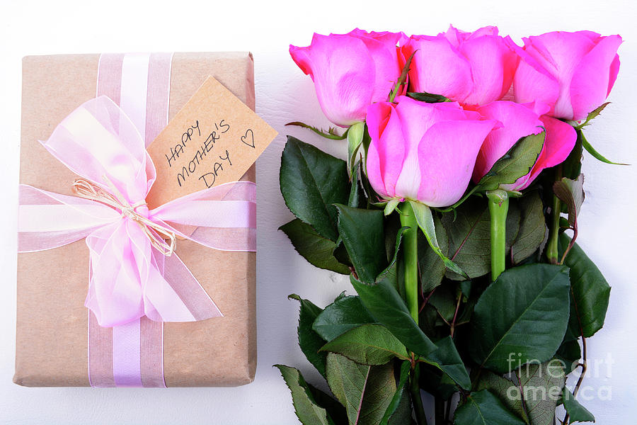 Brown Paper gift and pink roses.  Photograph by Milleflore Images