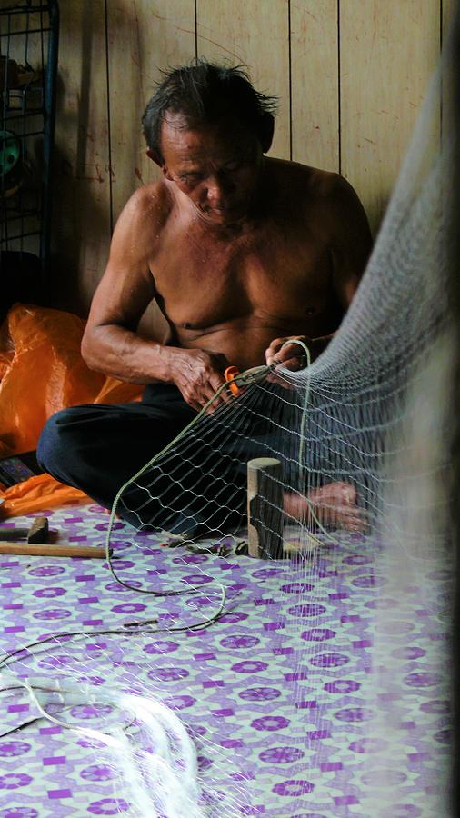 Bruneian Fisherman repairs the net Photograph by Robert Bociaga