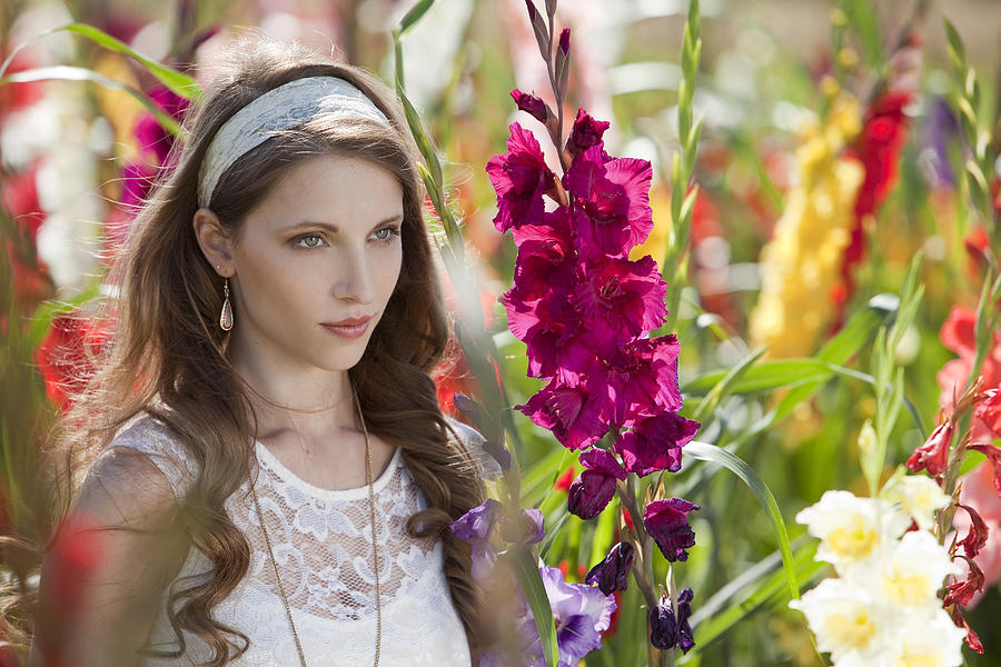 Brunette young woman surrounded by flowers Photograph by Stock4b-rf