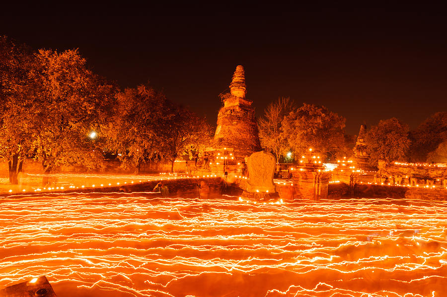 Buddhism walk with lighted candles trail around ancient temple Photograph by Real_shi