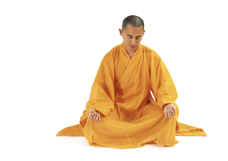 Buddhist monk sitting in lotus position, full length, blurred. Photograph by Marie Docher