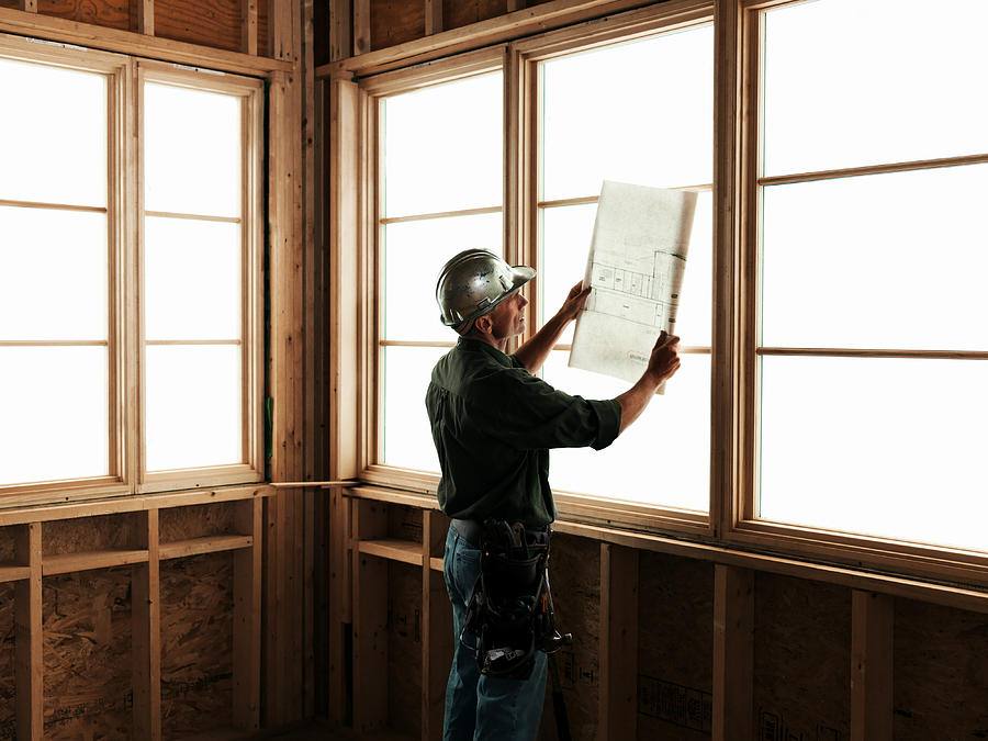 Builder with Blueprints in Front of Window Photograph by Stevecoleimages