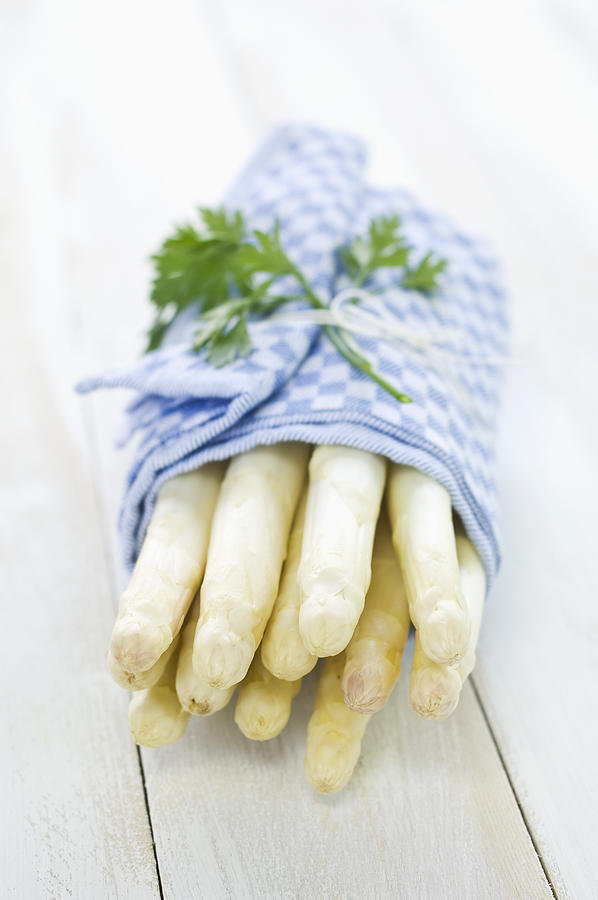 Bunch of white asparagus wrapped in kitchen towel Photograph by Westend61