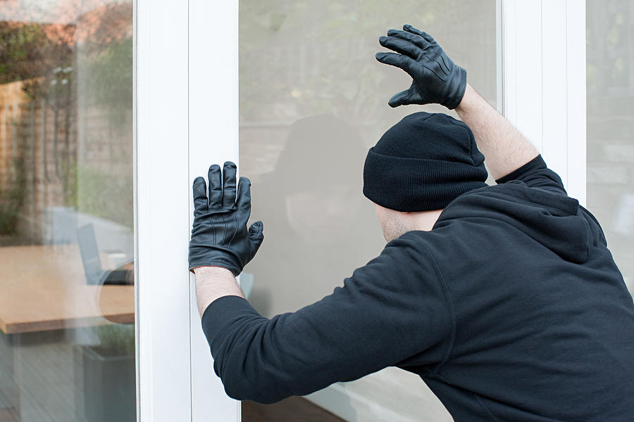 Burglar looking through window Photograph by Image Source